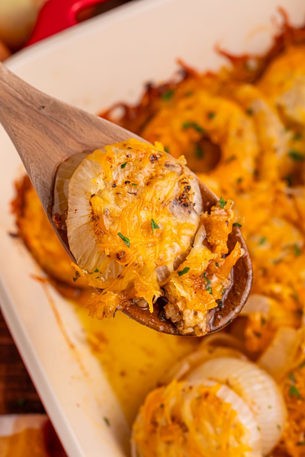 wooden spoon with baked cheesy onions on it