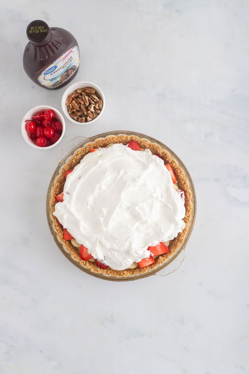 whipped cream spread over the top of a banana split pie