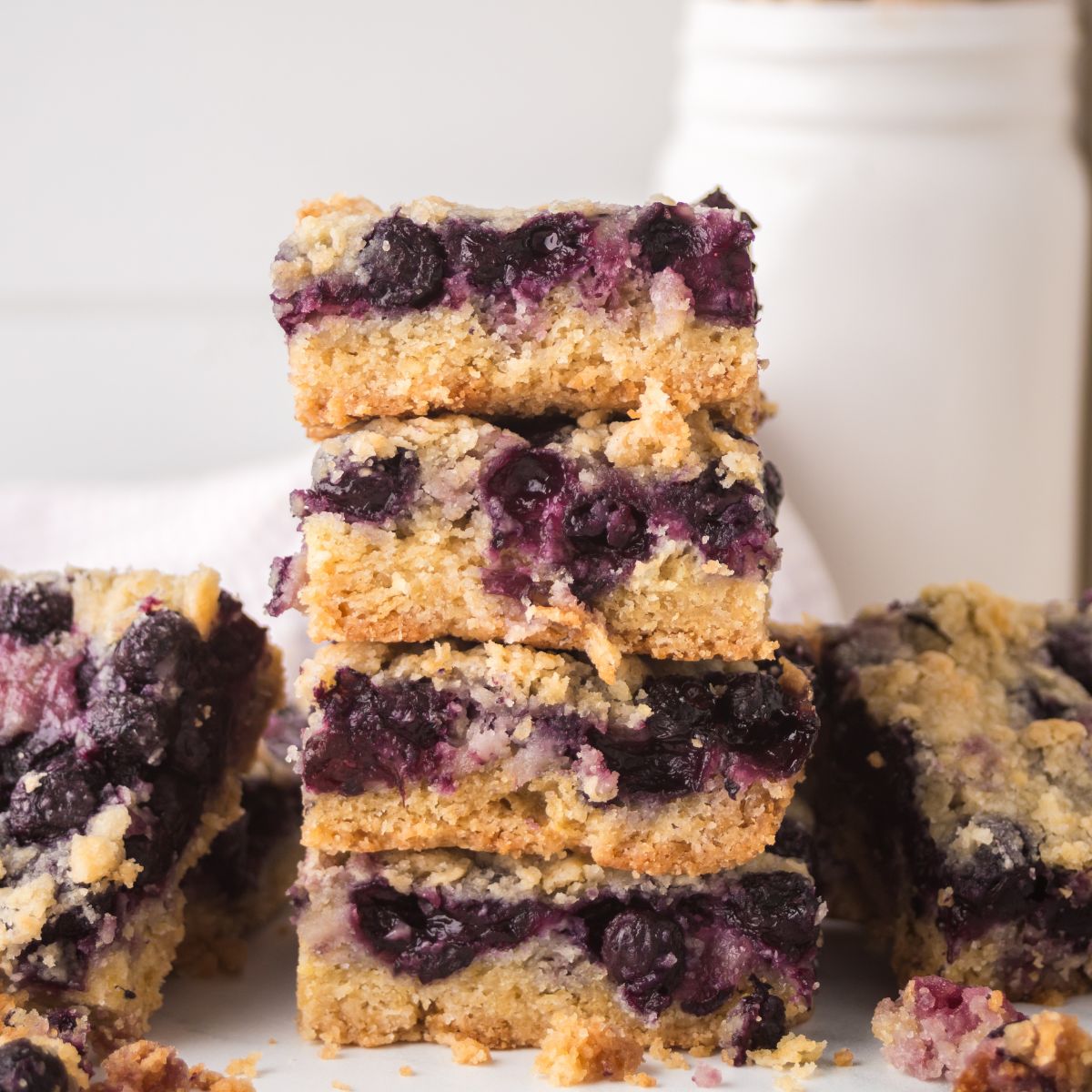 Blueberry Crumb Bars on table and a few stacked on top of each other