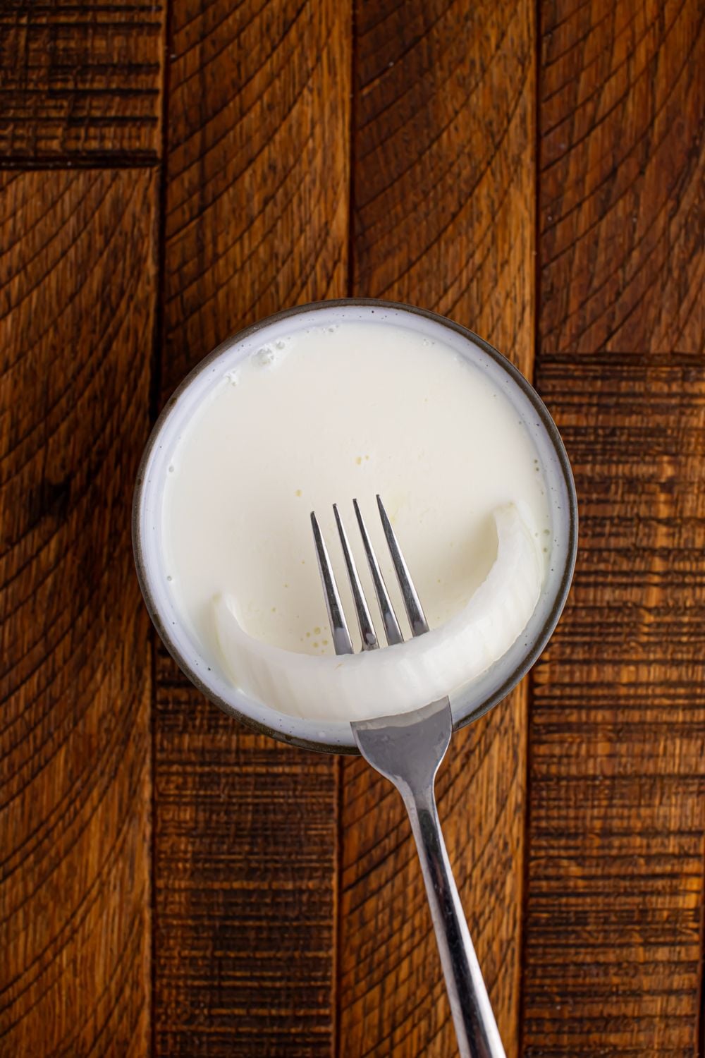 buttermilk in a bowl with onion being pulled out with a fork