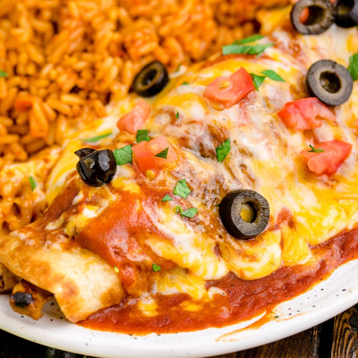 Cheesy Chicken Enchilada on plate with a side of Mexican rice