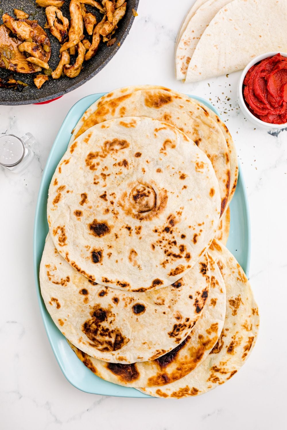 cooked tortillas stacked on a plate