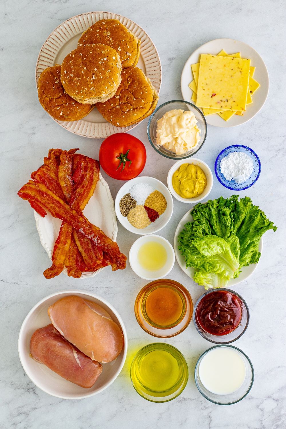 ingredients for Chick Fil A Grilled Chicken Sandwiches all laid out on table in single serve bowls for each of the ingredients 