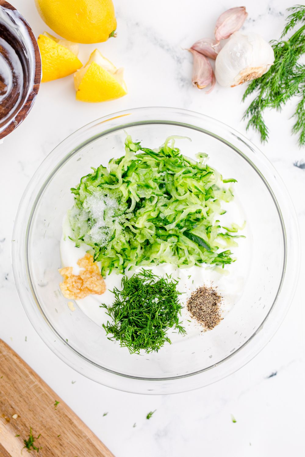 ingredients for Tzatziki Sauce in a glass bowl on table