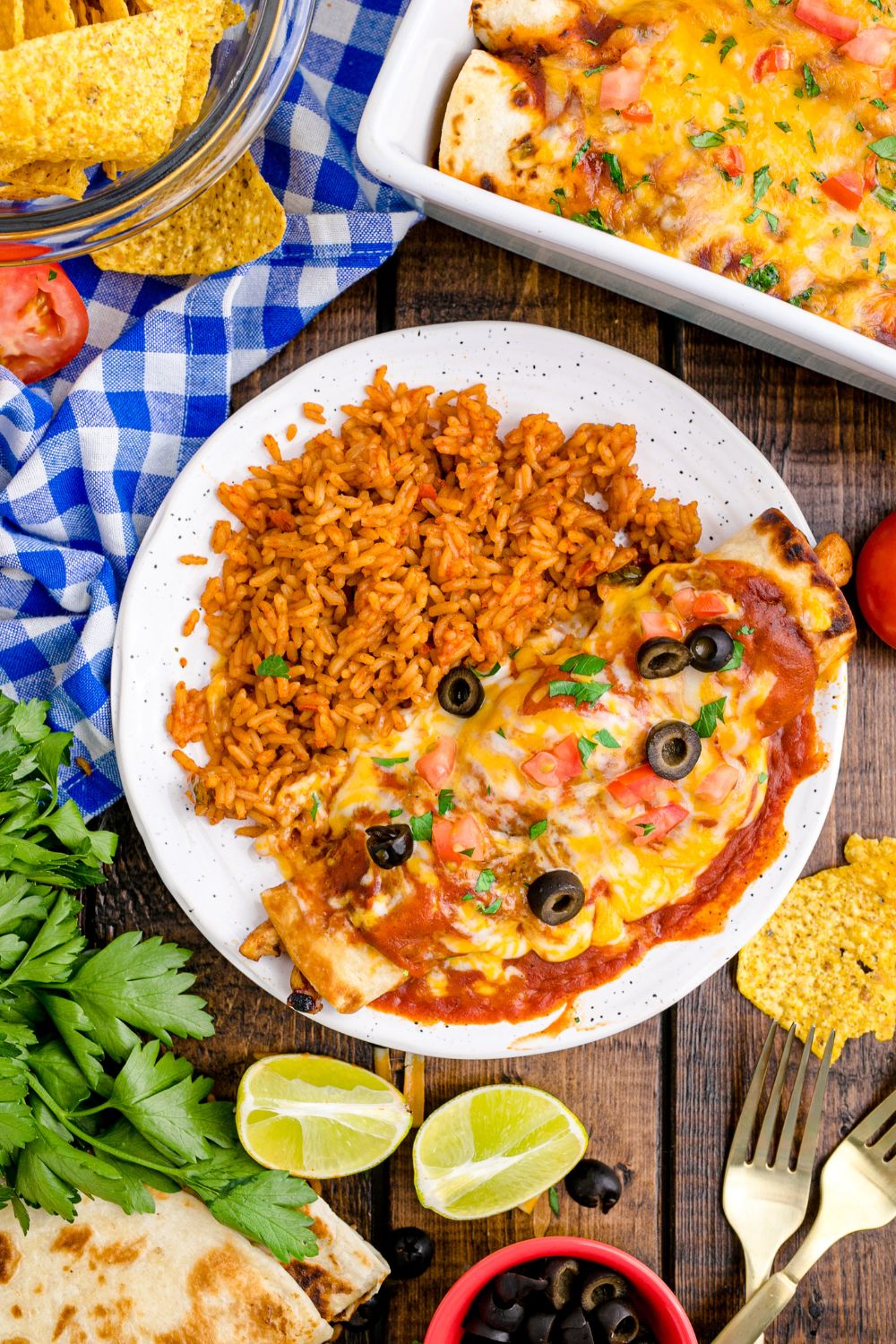 Cheesy chicken Enchilada on plate with a bed of rice on plate as well