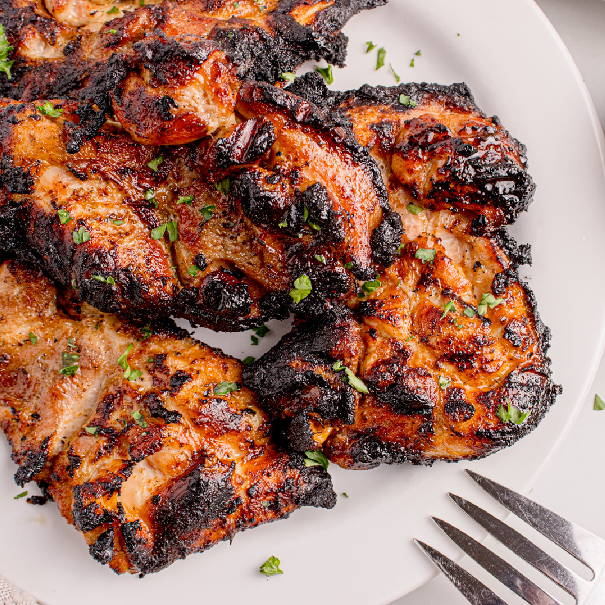 Grilled Chicken Thighs up close on a white plate 