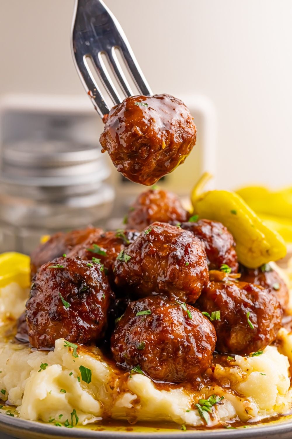 Crockpot Mississippi Meatballs on a plate with a fork lifting one off the plate