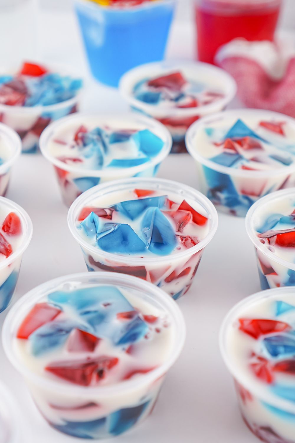 red, white and blue jello shots in containers on table