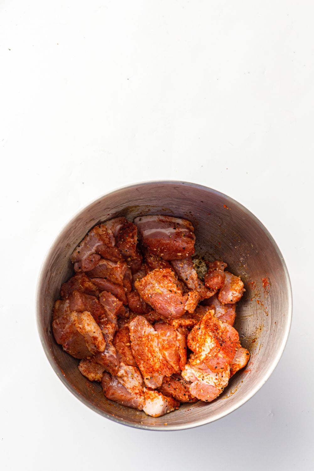 seasoned pork belly in a metal bowl on table