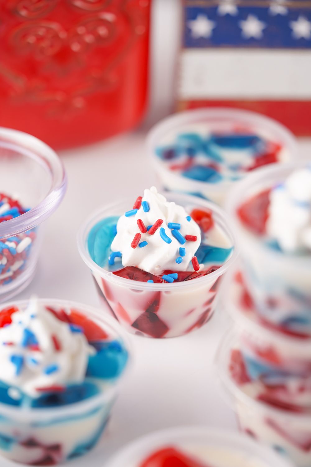 Red White and Blue Jello Shots with whipped cream on top and red and blue sprinkles