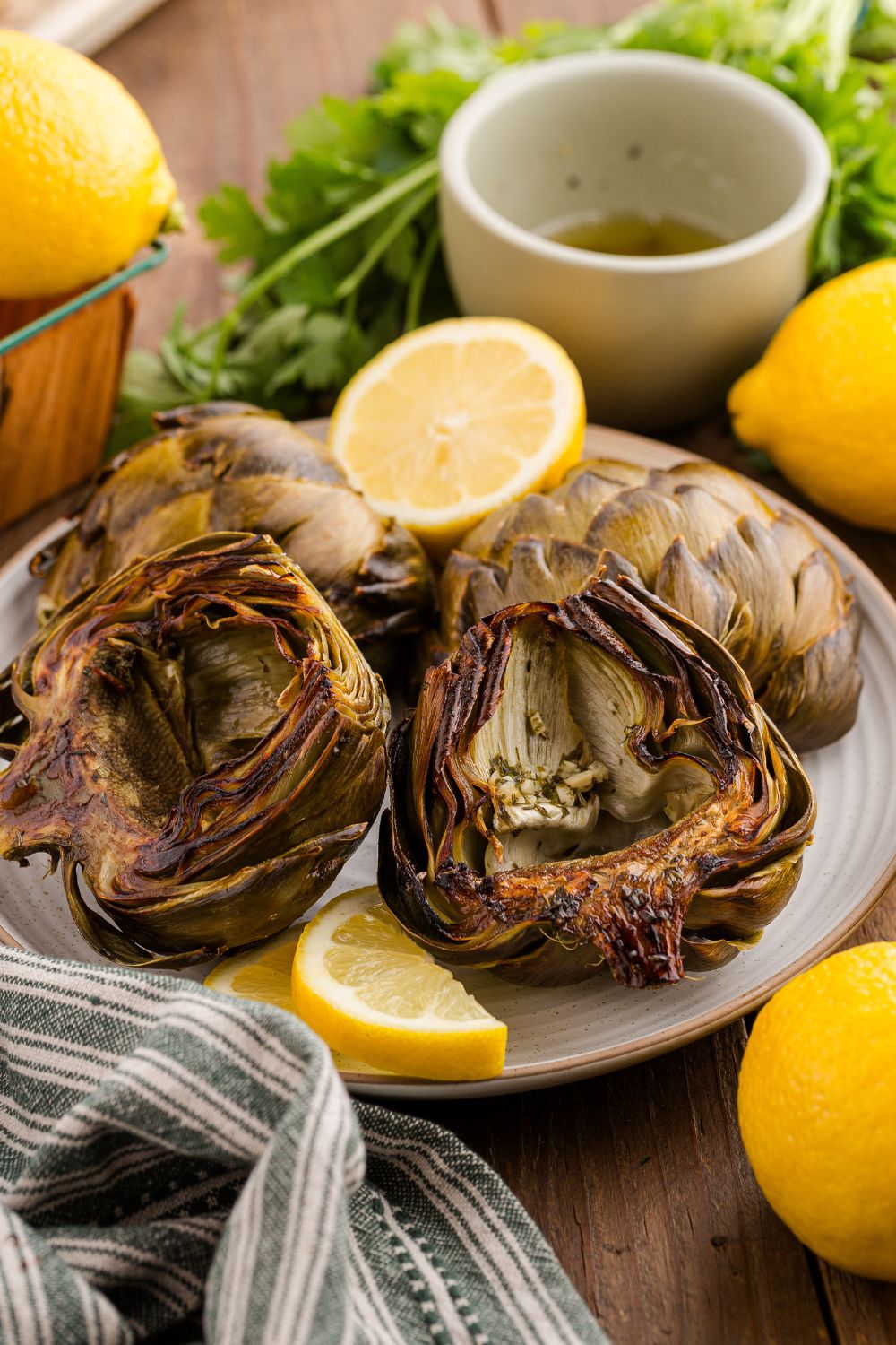plate with artichokes and lemon wedges around the table