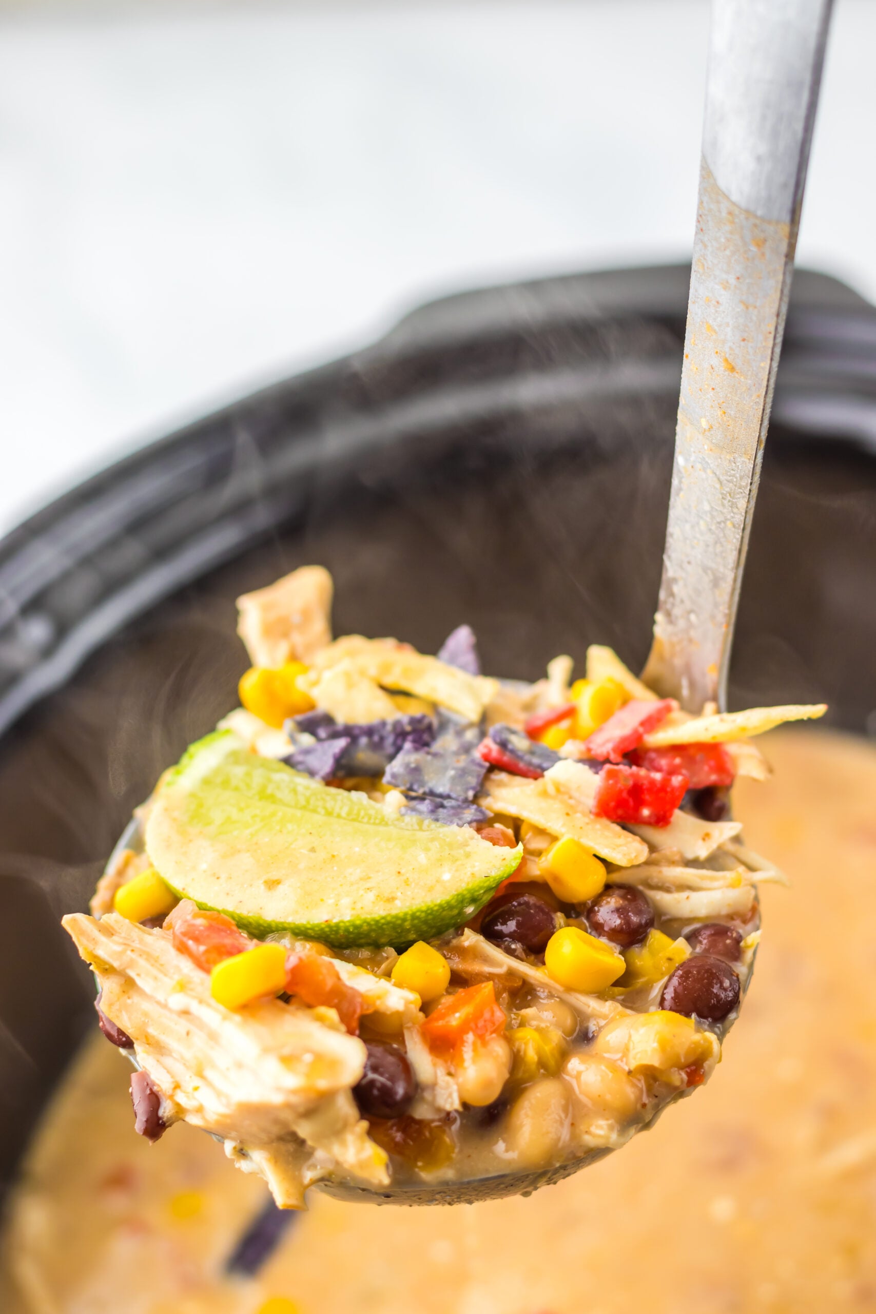 Slow Cooker Chick-Fil-A Tortilla Soup being lifting by a ladle