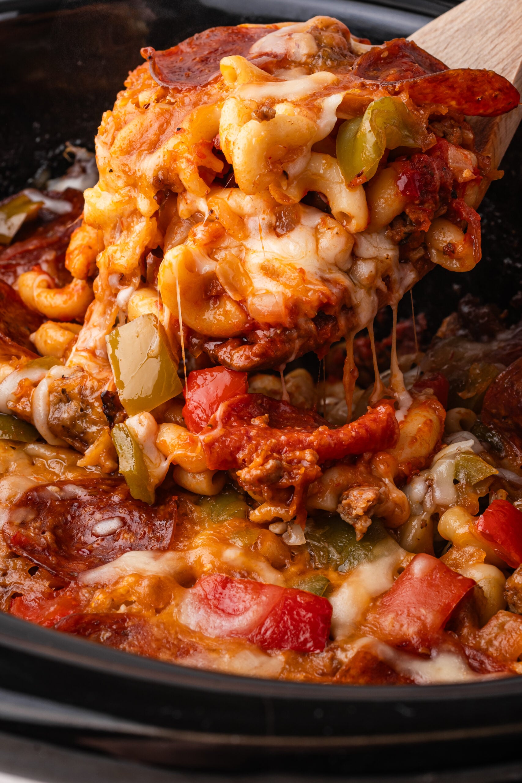 Slow Cooker Pizza Casserole up close being lifted by a spoon
