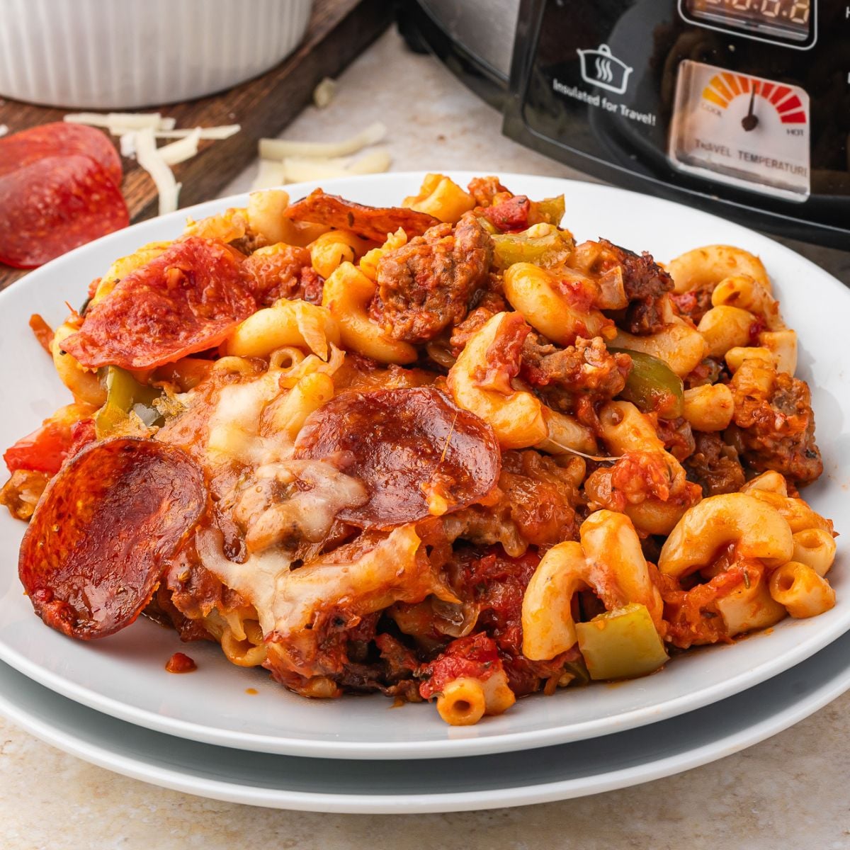 Pizza Casserole on a plate with slow cooker behind it