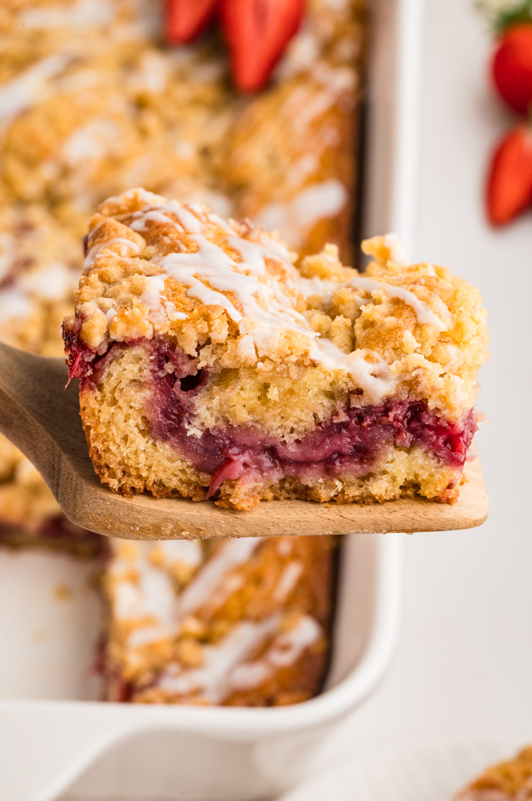 Strawberry Coffee Cake on a wooden spatula being lifted up