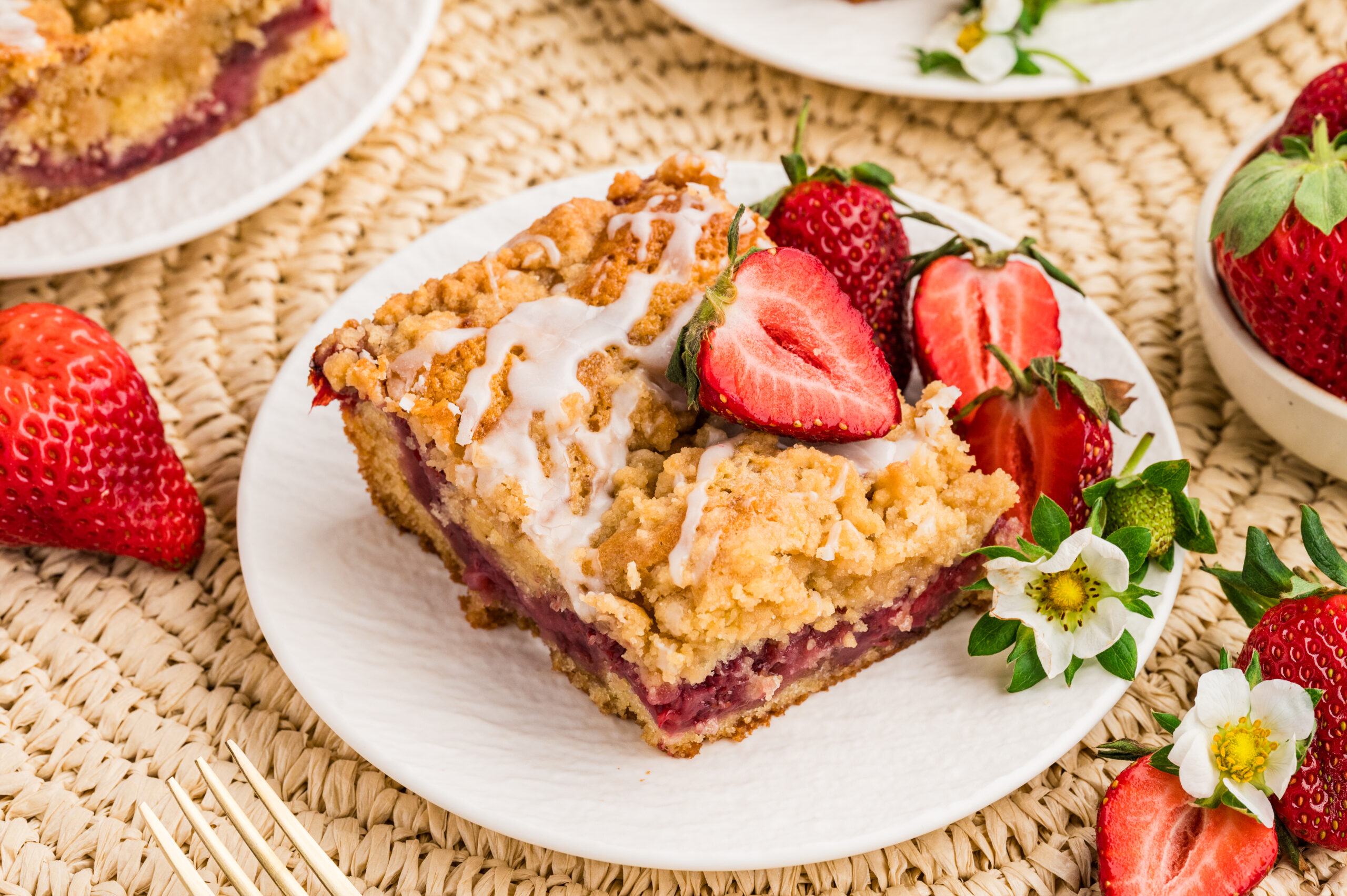 overhead shot of the Strawberry Coffee Cake on a white plate with sliced strawberries