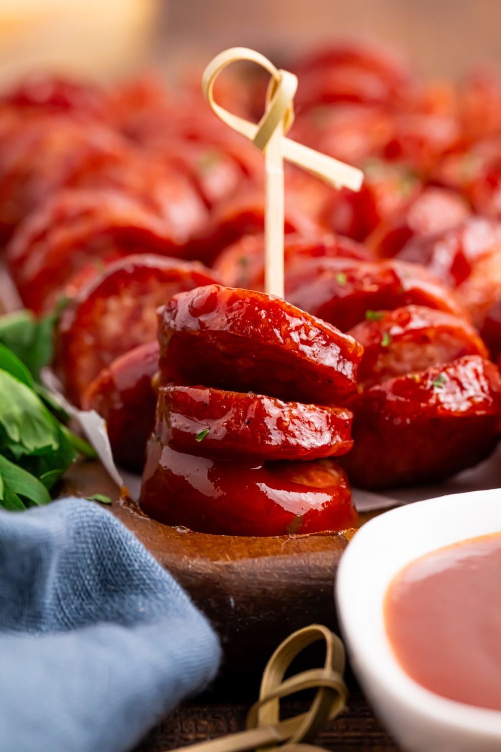 BBQ Hasselback Smoked Sausages on serving tray with one with a toothpick in it to show it is an appetizer