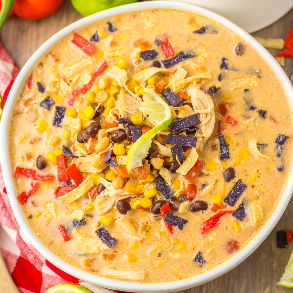 Close up view of some corn, bean, and tortilla chip toppings on tortilla soup. 