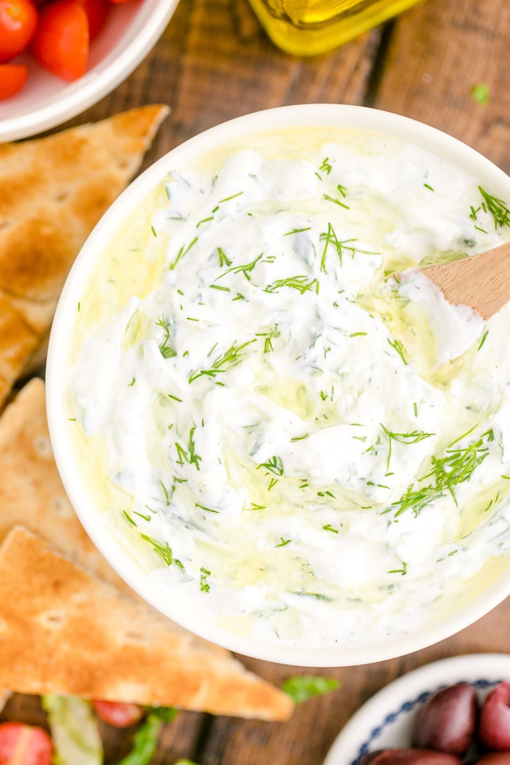 overhead look of Tzatziki Sauce in a bowl topped with fresh dill