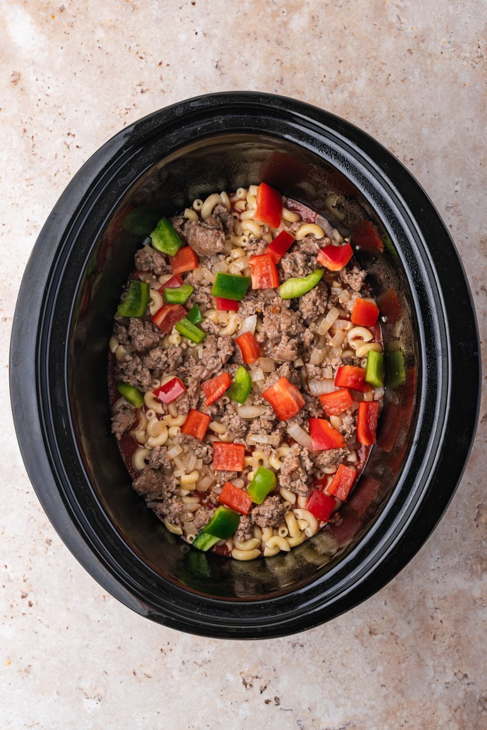 overhead look of Slow Cooker Pizza Casserole being assembled
