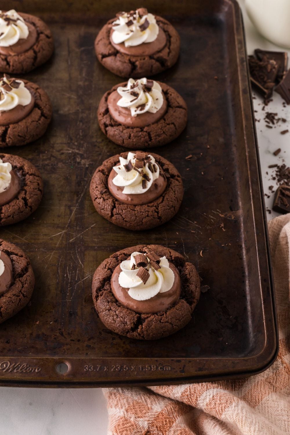 cookie tray with chocolate pie cookies topped with whipped cream and chocolate shavings
