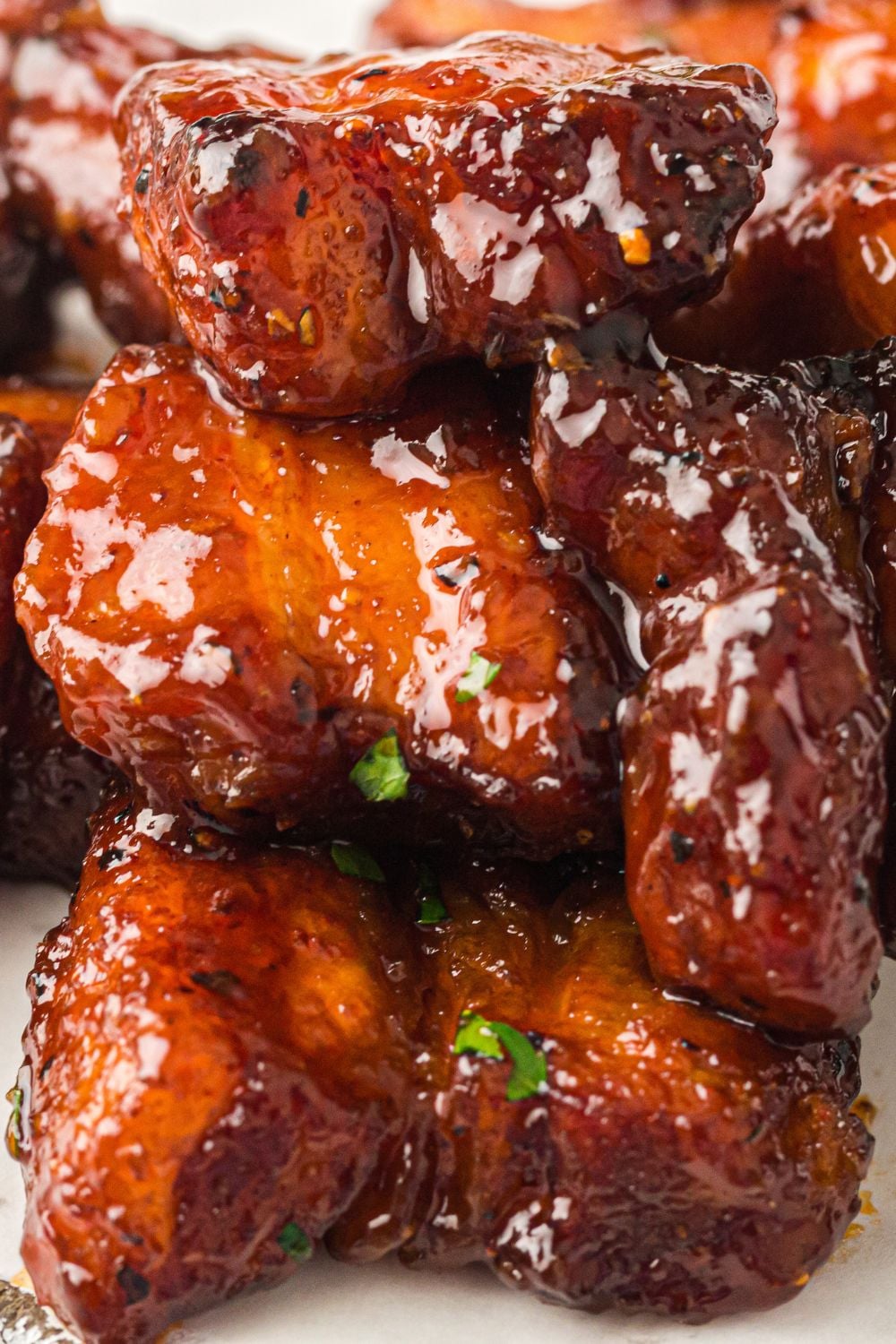 Smoked Pork Belly Burnt Ends stacked on top of one another with herbs on top