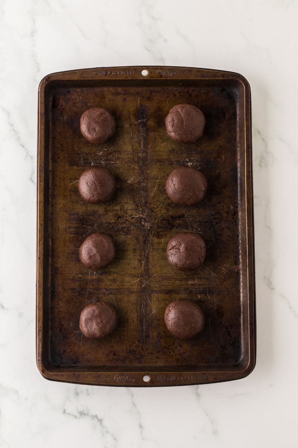 cookie tray with chocolate cookie balls spread out evenly