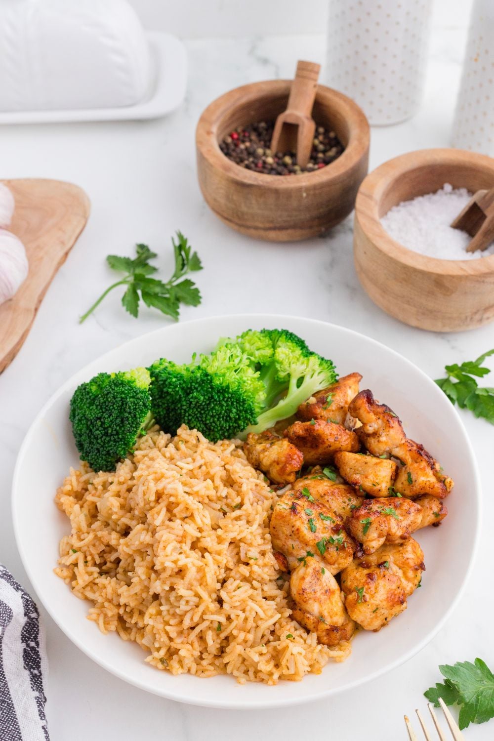 plate on table with Garlic Butter Chicken Bites , rice and broccoli on it