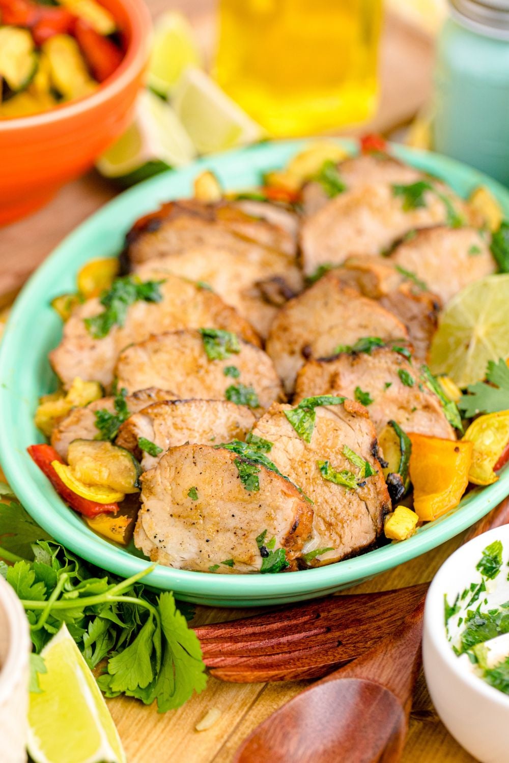 Grilled Pork Tenderloin sliced into wedges with fruit around it 