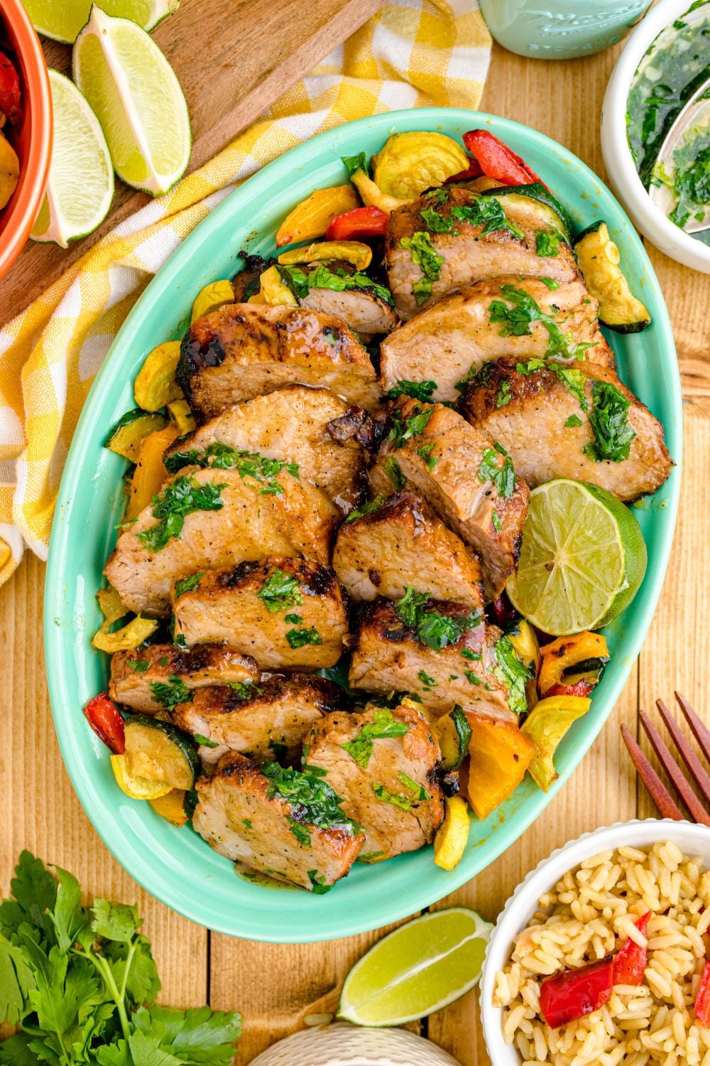 Grilled Pork Tenderloin on a tray with limes and rice beside the tray 