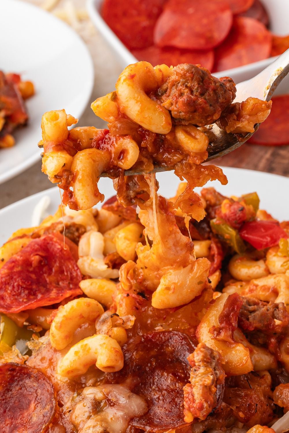 pizza casserole being scooped up with a fork off plate
