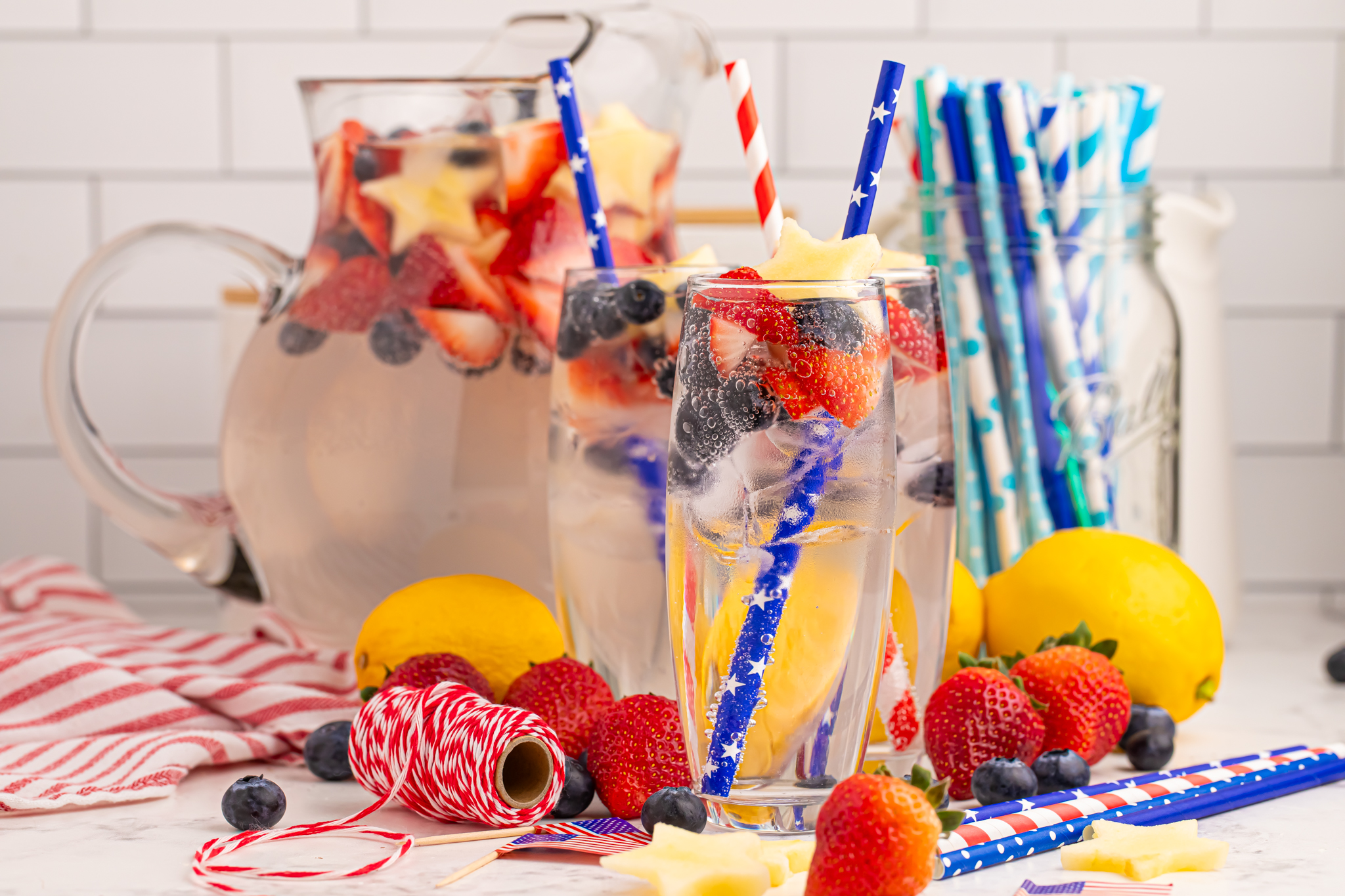 Patriotic Sparkling Lemonade in glasses with fruit scattered on table to add a pop of color 
