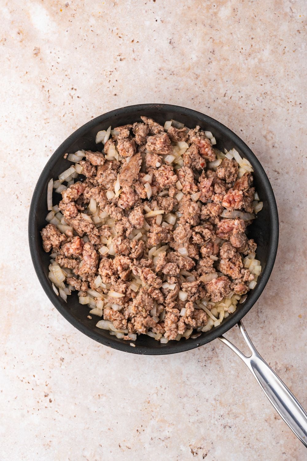 skillet with cooked hamburger and onions in skillet