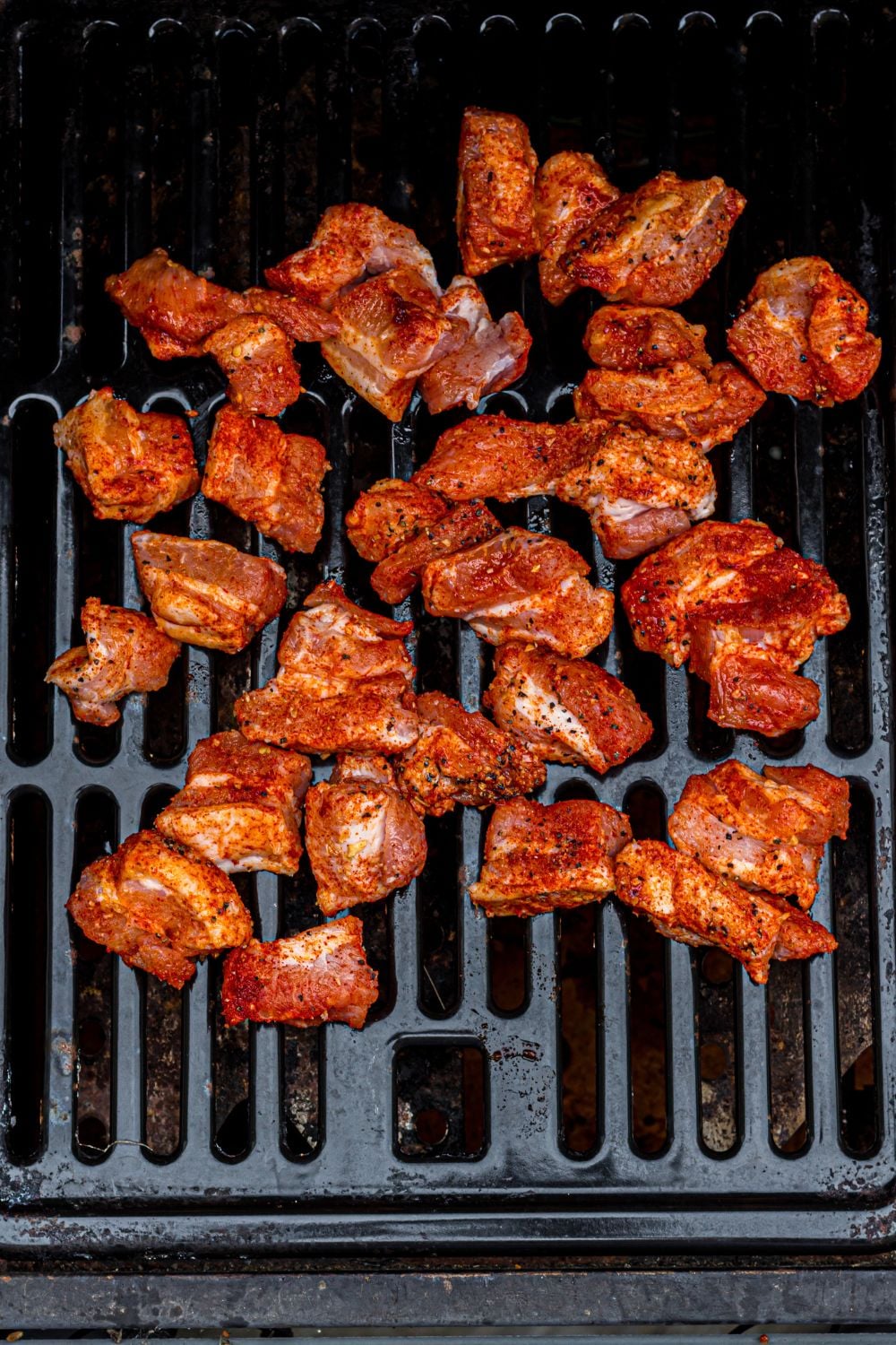 seasoned pork belly cubes on a grill
