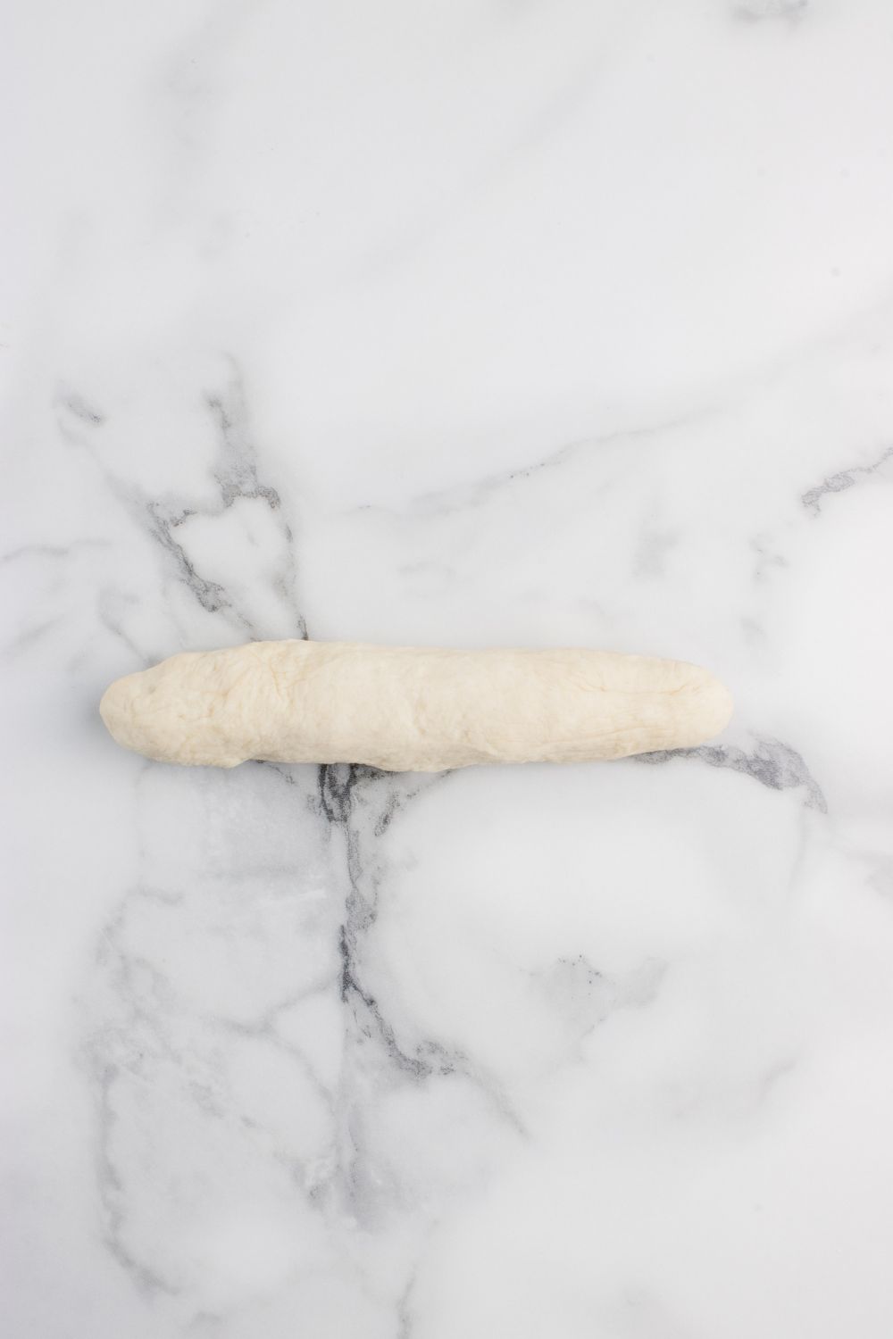 one dough ball rolled out into a snake 