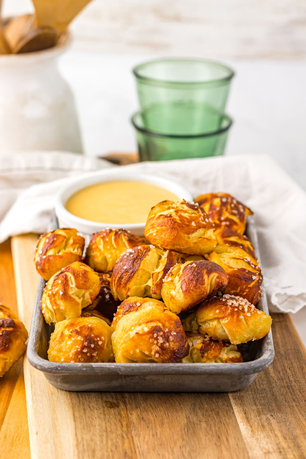 Easy Biscuit Pretzel Bites with Cheese Sauce on a tray with towel behind it on table