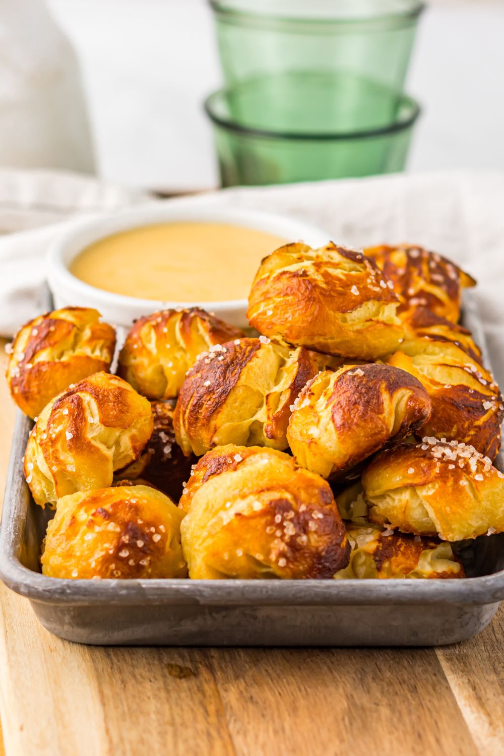 close up of Easy Biscuit Pretzel Bites with Cheese Sauce in a tray sitting on a table
