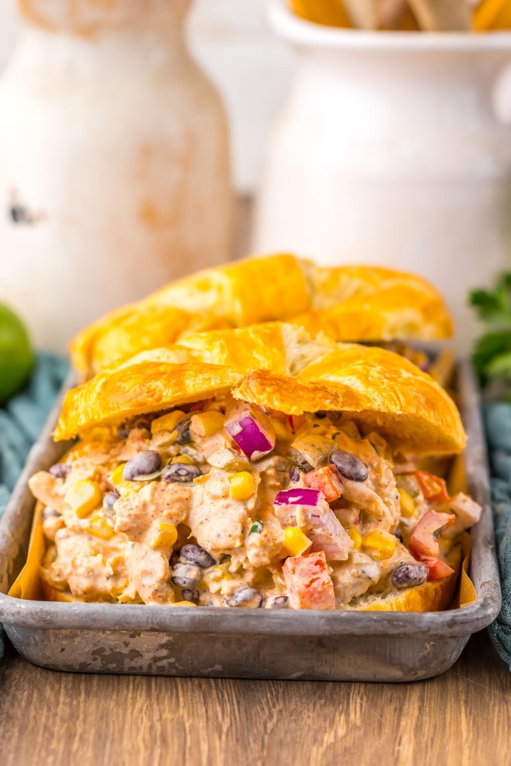 view of Creamy Taco Chicken Salad sandwiches on table with mason jar behind on table