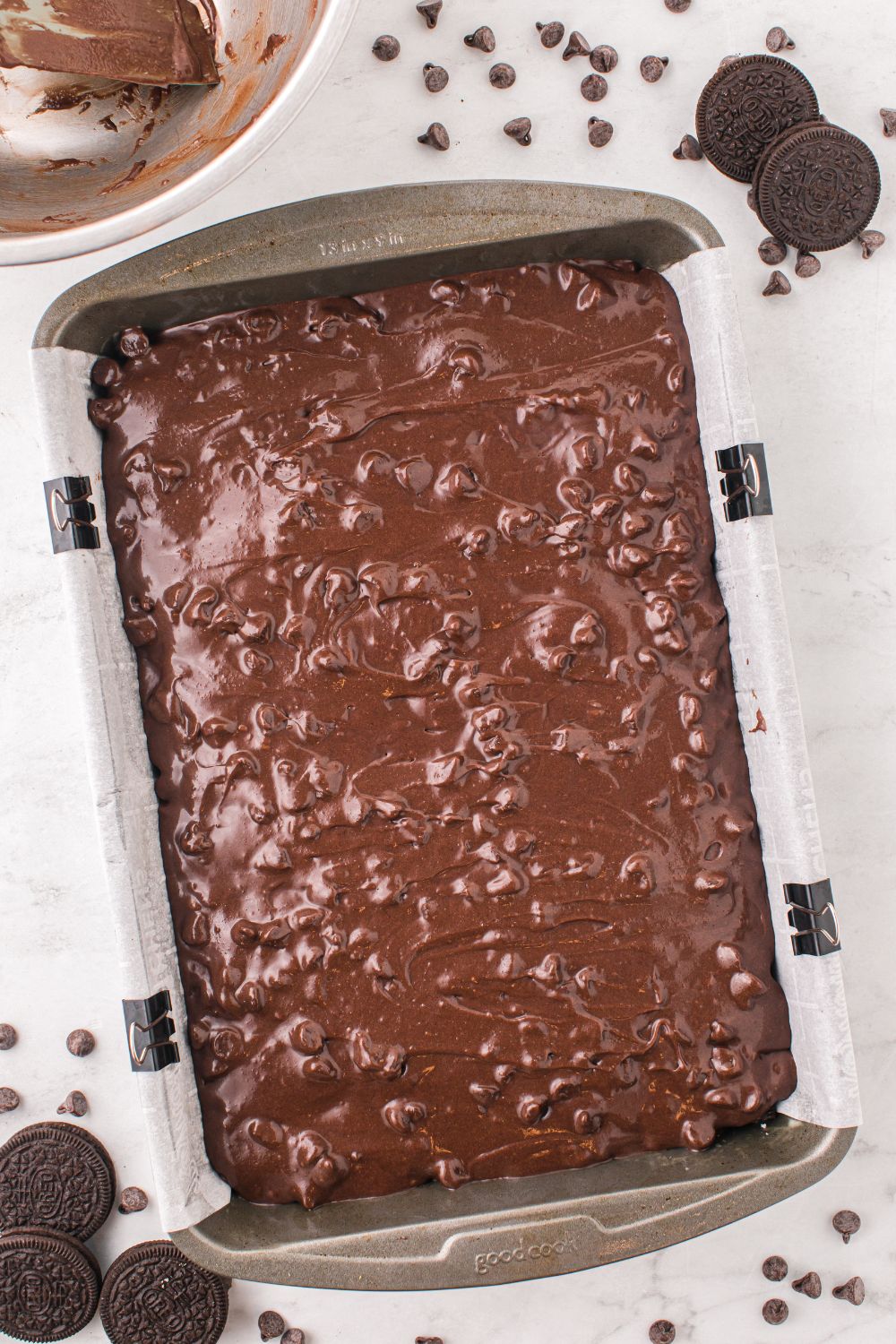 raw brownie batter in pan with chocolate chips on top 