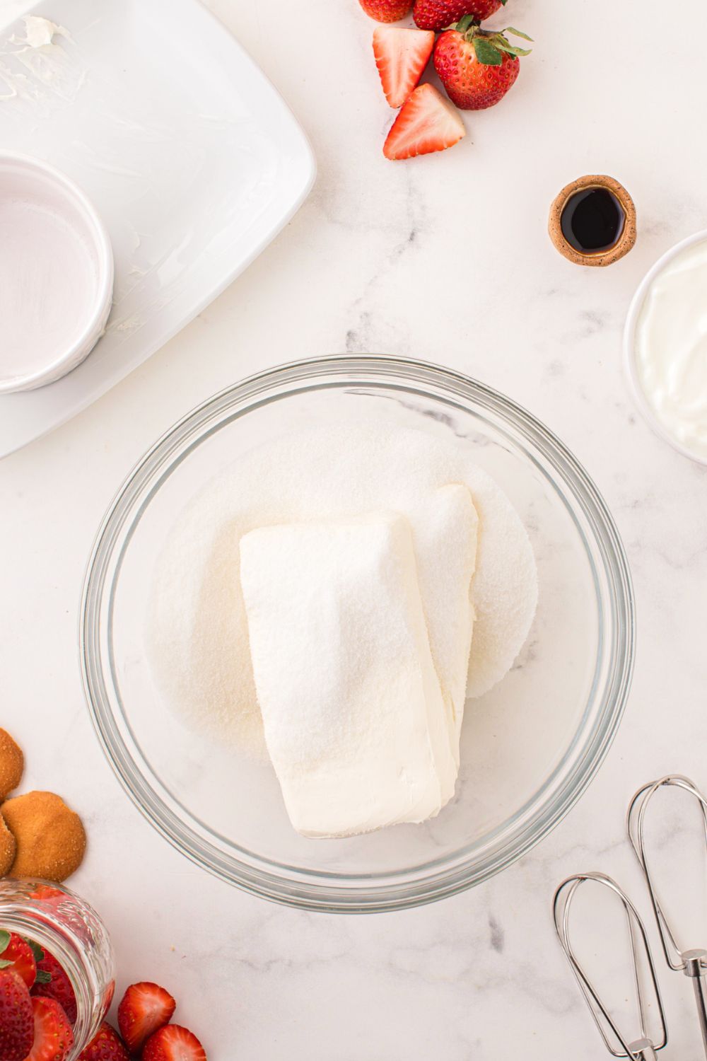 cream cheese and sugar in a glass bowl on table
