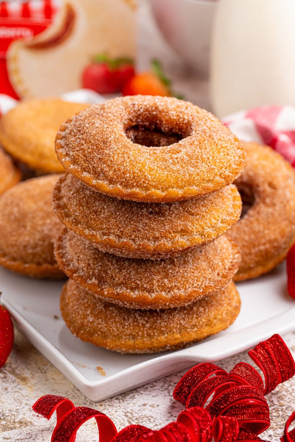 Fried Strawberry Uncrustables stacked on plate with more spread out behind it on tray 