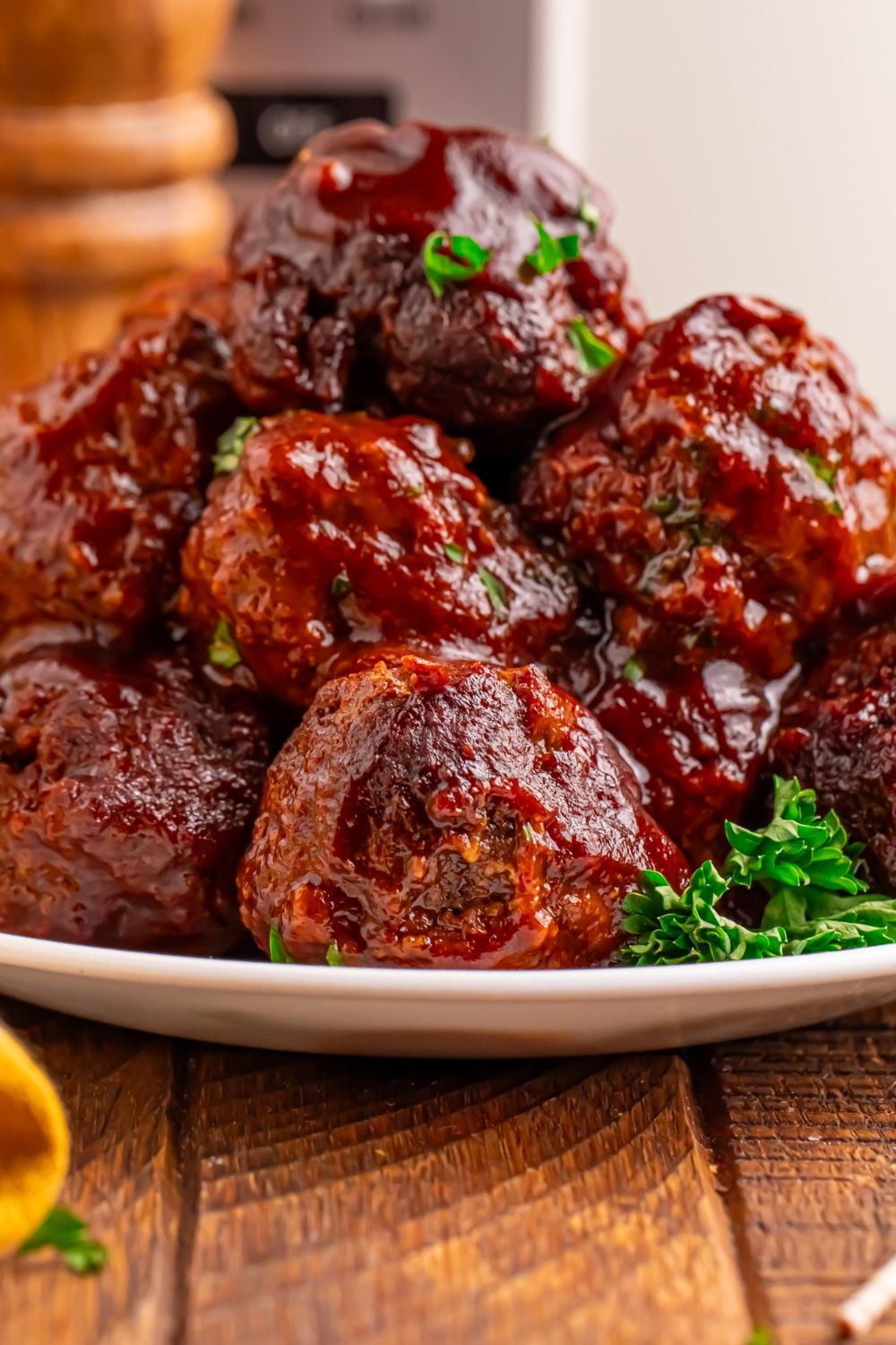 Crockpot Homemade BBQ Meatballs placed on a plate with salt and pepper shaker to side of table