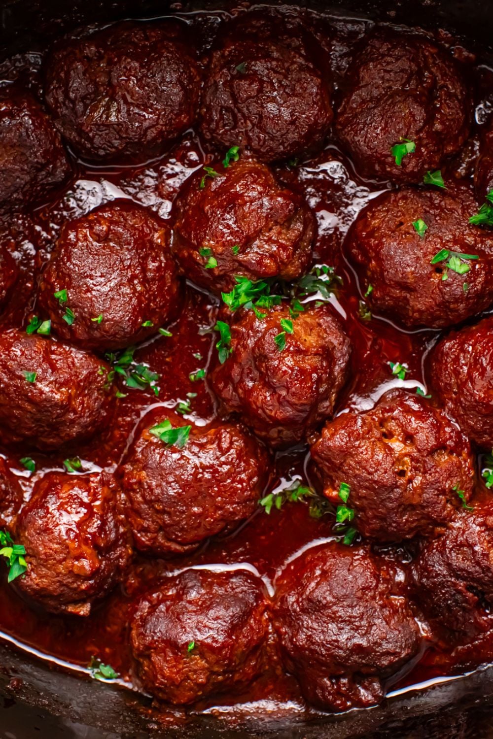 CrockPot full of meatballs in it topped with parsley