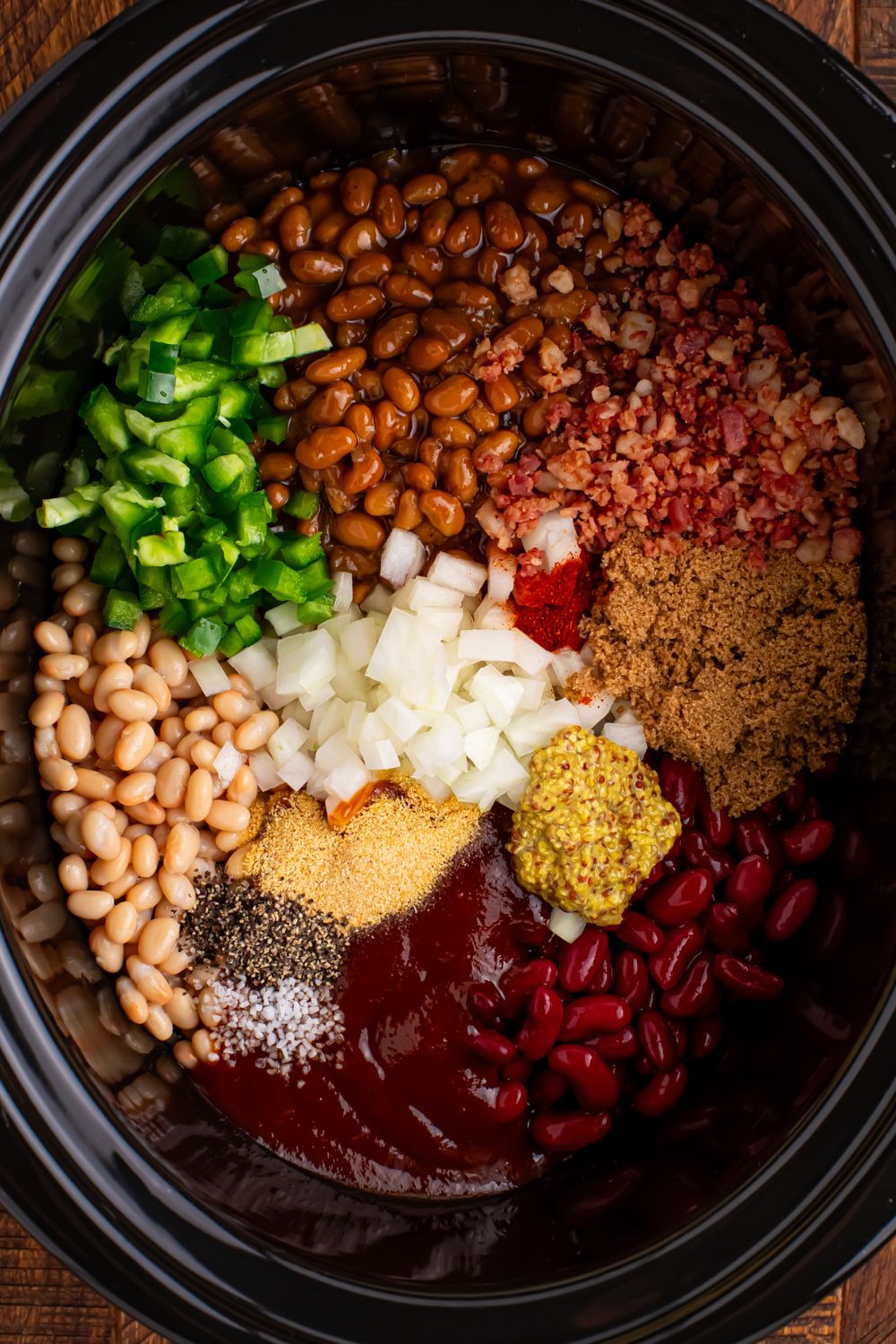 all the ingredients poured into the crockpot for making bourbon baked beans