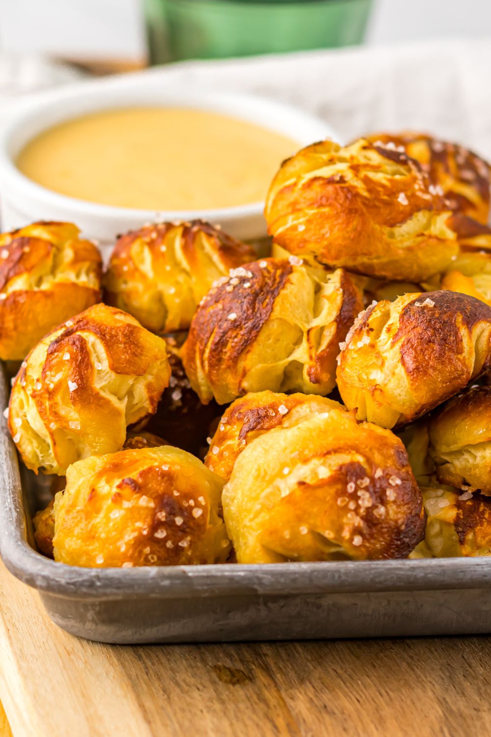 Easy Biscuit Pretzel Bites with Cheese Sauce in a pan with a close up view of it on table