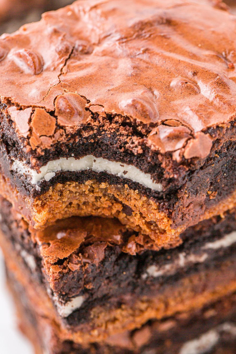 Slutty Brownies stacked on top of one another with a bite taken out of one brownie