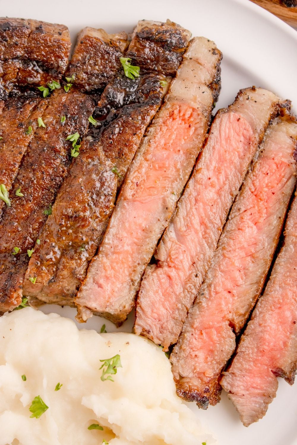 Grilled Ribeye Steak cut into thicker strips showing the medium rare doneness of the steak