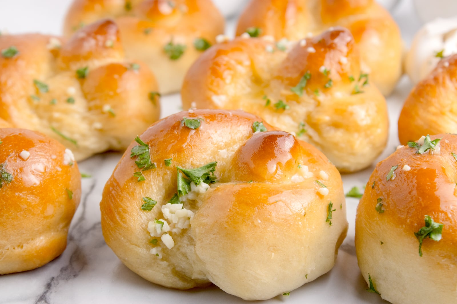 Homemade Garlic Knots on a white marble table 