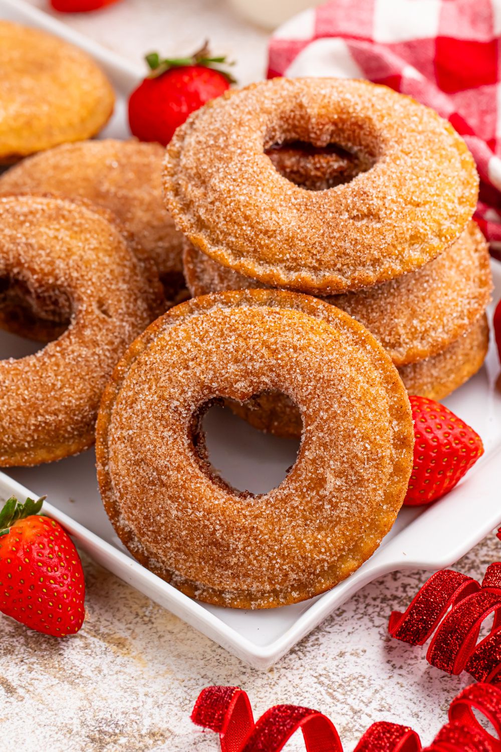 Uncrustables on a plate with hearts cut out and strawberries around table 