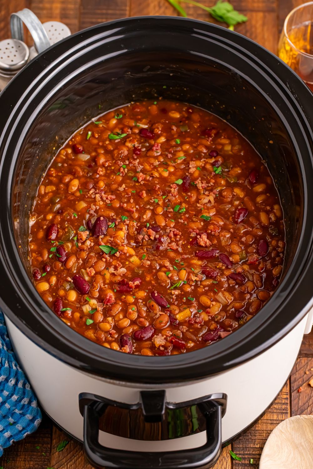 crockpot sitting on table with bourbon baked beans inside